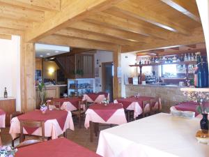 un restaurante con mesas y sillas rojas y una barra en Residence Hotel Montegargnano, en Gargnano