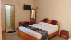 - une chambre avec un lit et une télévision dans l'établissement Hotel Alas Garden, à Trincomalee