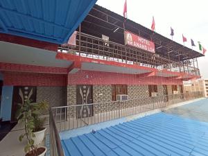 a building with a swimming pool in front of it at Hotel Anand LOK in Rājgīr