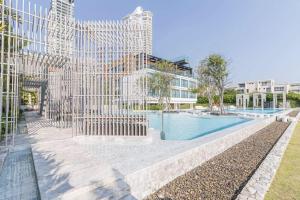een gebouw met een zwembad voor een gebouw bij Veranda Residence by GoldStar Group in Jomtien Beach