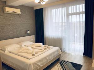 a bedroom with a bed with white sheets and a window at Pensiunea Amso in Sibiu