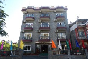 un alto edificio in mattoni con bandiere di fronte di Hotel Tulip Pokhara Inn a Pokhara
