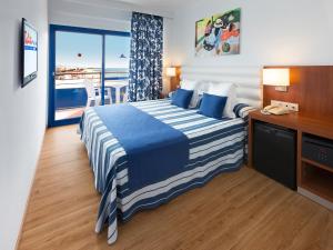 a bedroom with a bed with a view of the ocean at Hotel Tahití Playa in Santa Susanna