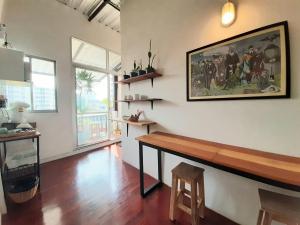a living room with a table and a painting on the wall at Pingplalee Female House in Bangkok