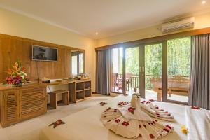 sypialnia z dużym łóżkiem i dużym oknem w obiekcie Alamdini Resort Ubud w mieście Ubud