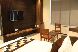 a bedroom with a bed and a tv and a table at Hotel City Point in Phalodi