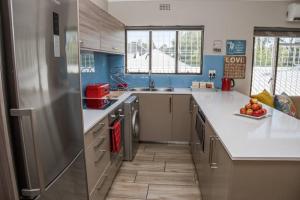 una cucina con frigorifero in acciaio inossidabile e lavandino di Apartment Claudia a Stellenbosch