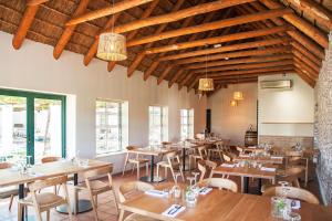ein Restaurant mit Holztischen und -stühlen und Holzdecken in der Unterkunft Rijk's Wine Estate & Hotel in Tulbagh