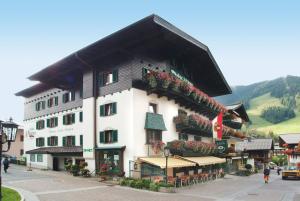 a large white building with flowers on the side of it at Hotel Mitterer in Saalbach Hinterglemm