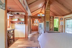 a room with a bed and a kitchen with wooden walls at Dear Ol' Dad's Cabin in McKinleyville