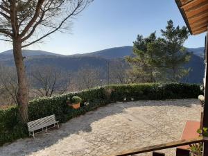 a bench sitting on a patio with mountains in the background at villamuna in Ferentillo