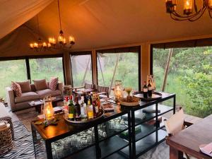 una sala de estar con una mesa con botellas de vino. en Simbavati Trails Camp, en Reserva Timbavati