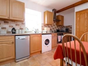 een keuken met een wasmachine en een vaatwasser bij Niffany Barn in Skipton