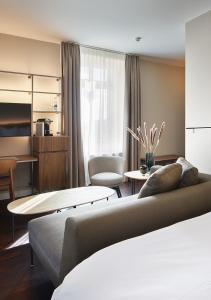 uma sala de estar com um sofá e uma mesa em Sorell Hotel Zürichberg em Zurique