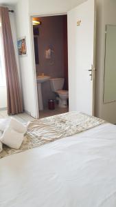 a bedroom with a bed and a bathroom with a toilet at Hôtel Restaurant le Bellevue in Propriano