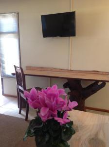 a vase of purple flowers sitting on a table at Centurion Guest House and Lodge in Centurion