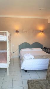 una camera con un letto e un letto a castello di Hôtel Restaurant le Bellevue a Propriano