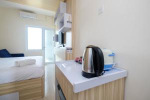 a kitchen with a toaster sitting on a counter at Elegant Studio Apartment at Bogorienze By Travelio in Bogor