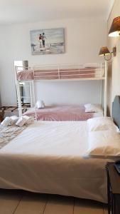 a bedroom with a bed and a bunk bed at Hôtel Restaurant le Bellevue in Propriano