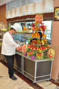 a chef standing in front of a display of fruits and vegetables at Ananas Hotel in Alanya