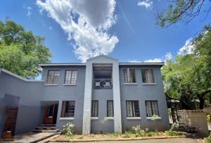 uma grande casa branca com um céu em Boutique@Milner Guesthouse em Bloemfontein