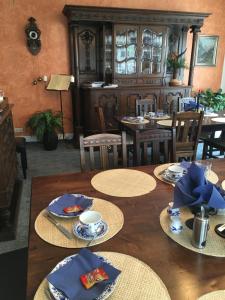 una sala da pranzo con tavoli, sedie e tovaglioli blu di Pension Wegerich a Erfurt