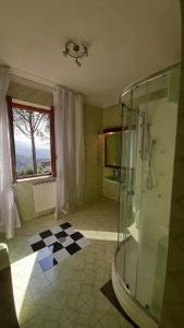 a bathroom with a glass shower and a checkered floor at villamuna in Ferentillo +147 photos