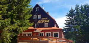 un edificio con un cartel en la parte superior en Pension Svoboda en Pec pod Sněžkou