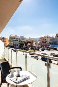einen Tisch und Stühle auf einem Balkon mit Stadtblick in der Unterkunft Apartments Chania in Chania
