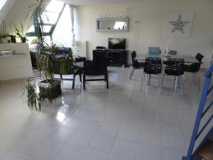 un soggiorno con tavolo, sedie e piante di Duplex residence d'orléans ad Amiens