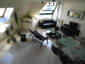 sala de estar con sofá, mesas y sillas en Duplex residence d'orléans en Amiens