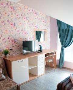 a room with a desk with a television and flowers at Provance Guest House in Tsemdolina
