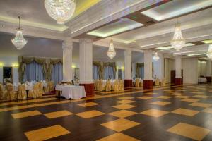 a large banquet hall with tables and chairs and chandeliers at Hotel Łańcut in Łańcut