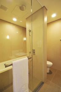 a bathroom with a glass shower and a toilet at Zenda Suites in Tainan