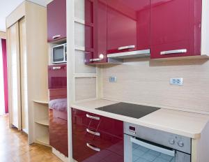 a kitchen with purple cabinets and a microwave at Apartma Žusterna in Koper