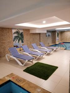 une piscine avec des chaises longues et une piscine dans l'établissement Al Maali Hotel Jazan, à Jazan
