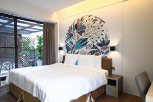 1 dormitorio con 1 cama grande y un mural de flores en la pared en Innk en Taichung