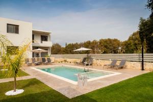 a swimming pool in a yard next to a house at Kagiemar Luxury House in Perivólia