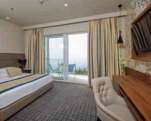 a hotel room with a bed and a balcony at Royal Neptun Hotel in Dubrovnik