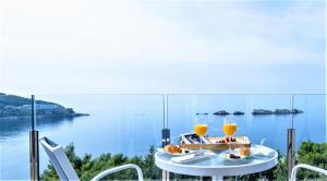 a table with two glasses of orange juice on top of it at Royal Neptun Hotel in Dubrovnik