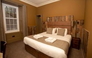 um quarto com uma cama com duas toalhas em The Whisky Vaults em Oban