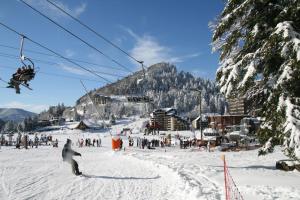 a group of people riding a ski lift in the snow at LE SAPORTA- Studios et Appartements meublés de tourisme in Le Lioran