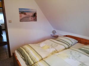 a bedroom with two beds and a picture on the wall at Ferienhaus Klabautermann in Hage