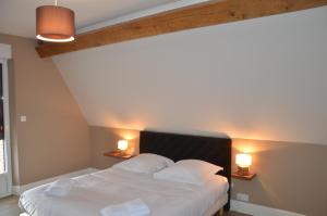 A bed or beds in a room at Auberge du Moulin à Vent, The Originals Relais (Relais du Silence)