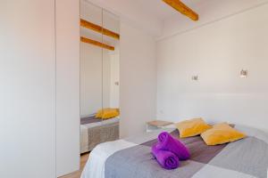 um quarto com um bicho de peluche roxo deitado numa cama em Słoneczne Poddasze przy molo i plaży em Sopot
