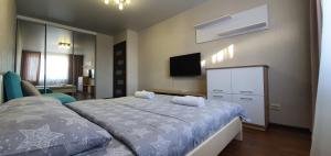 Schlafzimmer mit einem Bett und einem Flachbild-TV in der Unterkunft Затишна квартира з виглядом на парк in Ternopil