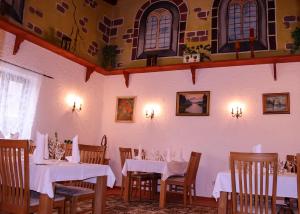 a dining room with tables and chairs with white table cloth at Landhotel-Restaurant Schwalbennest in Zierenberg