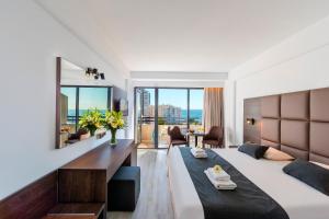 a bedroom with a large bed and a large mirror at Odysseia Hotel Kapetanios in Limassol