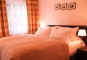 Un dormitorio con una cama con almohadas blancas y una ventana en Landhotel-Restaurant Schwalbennest, en Zierenberg