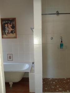 a bathroom with a shower and a tub and a sink at Sutherland Guest House in Sutherland